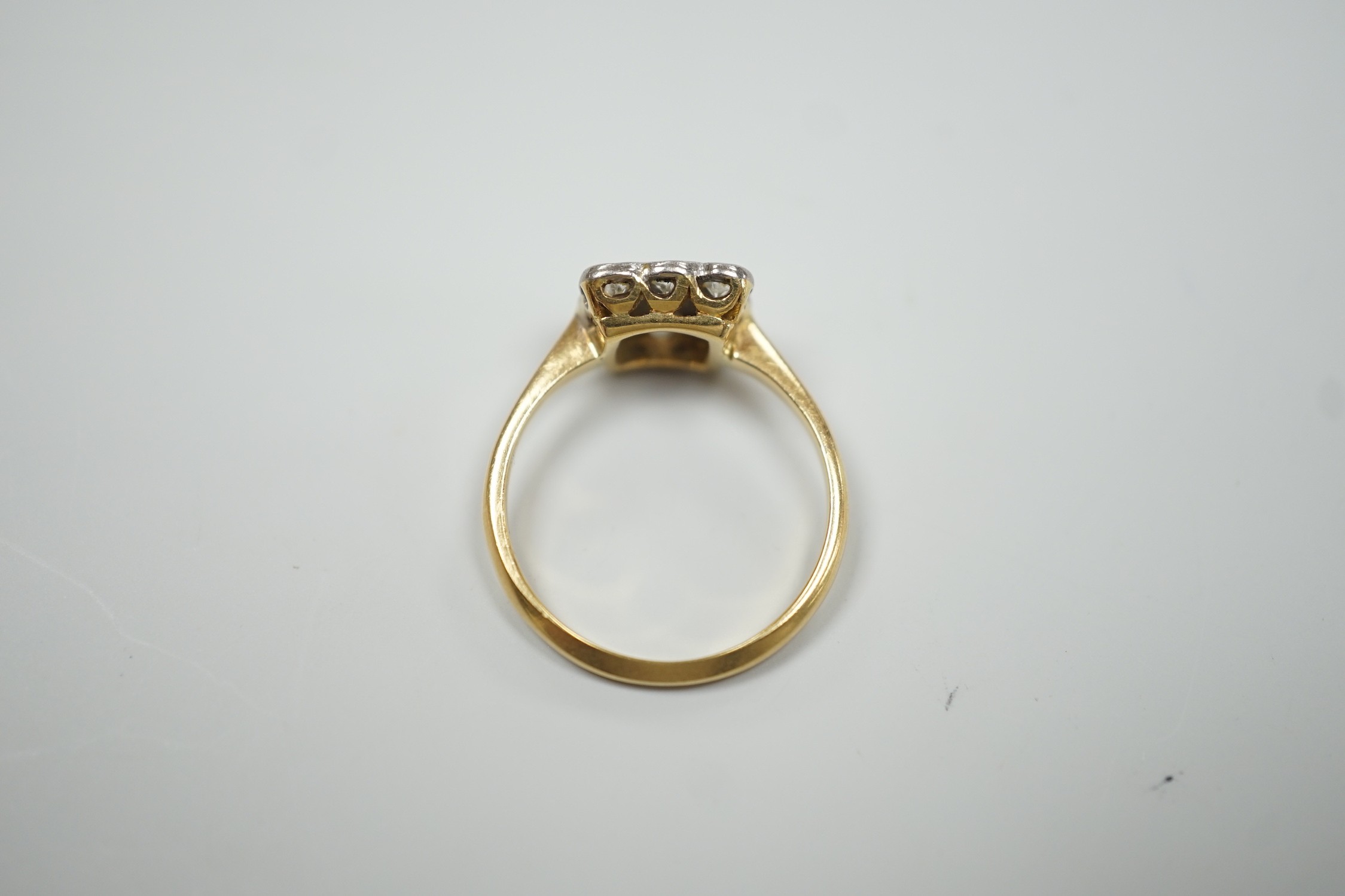 An 18ct and collet set nine stone diamond cluster table ring, size K/L, gross weight 2.6 grams.
